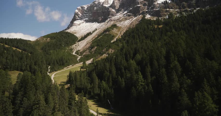 Looking down at a green forest stretching out from a rocky mountain peak
