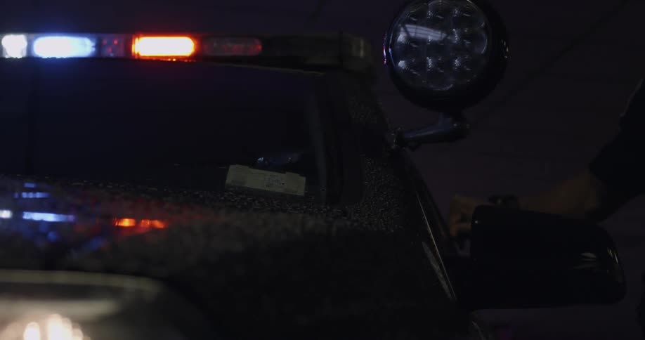 A police light flashing and someone shutting the door of the car