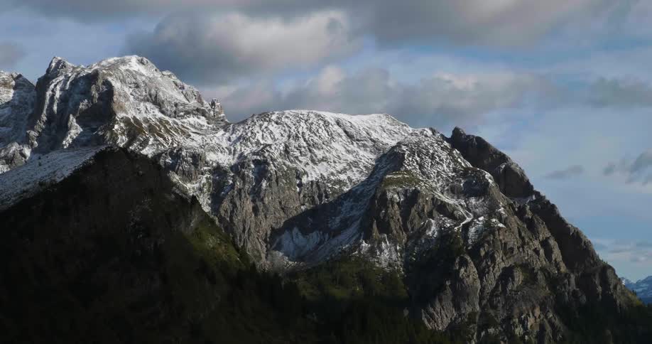 Large mountain covered with snow and cloudy skies in the back