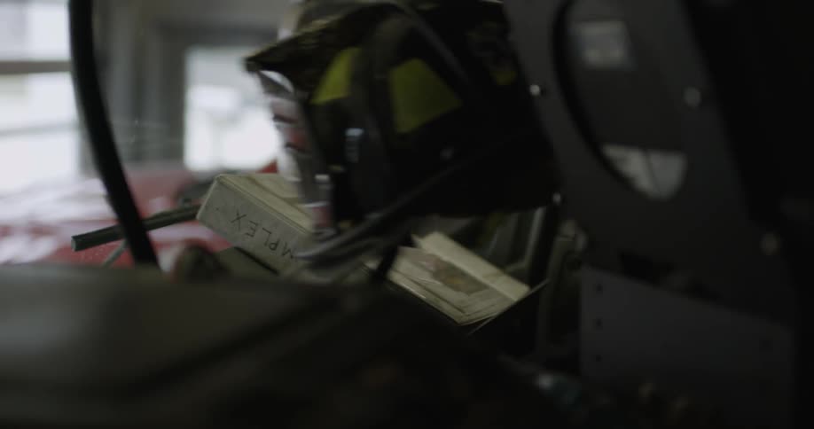A person picks up a safety helmet from a stack of other equipment