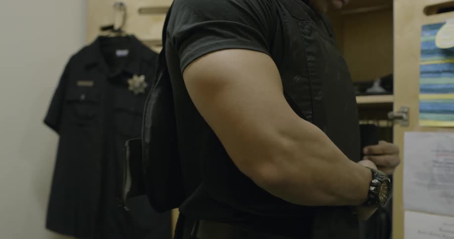 Man puts a vest on and buckles it
