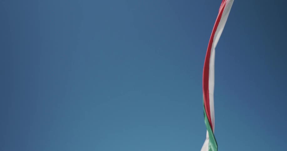 A red white and green banner breezes in the air