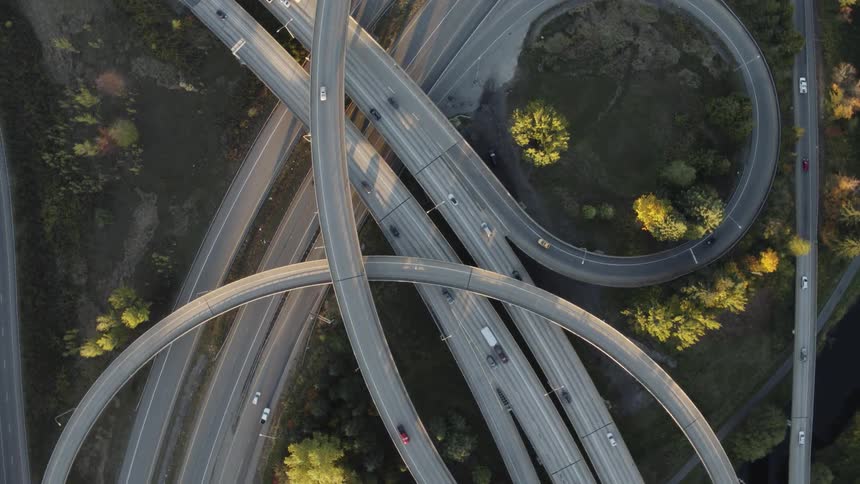 Twisting birds eye view of traffic flowing on a highway interchange