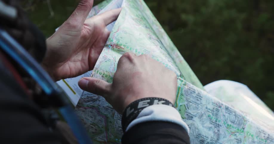 A woman is outdoors using a paper map
