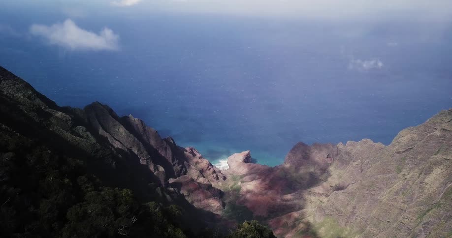 Waves lap against the shore far below steep cliffs