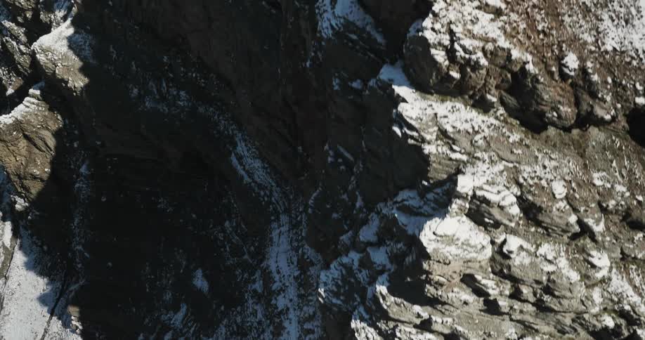 A rocky, snow dusted mountain