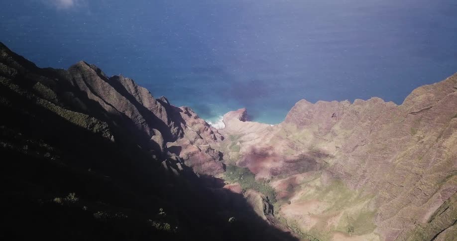 Blue water flows up to shoreline cliff