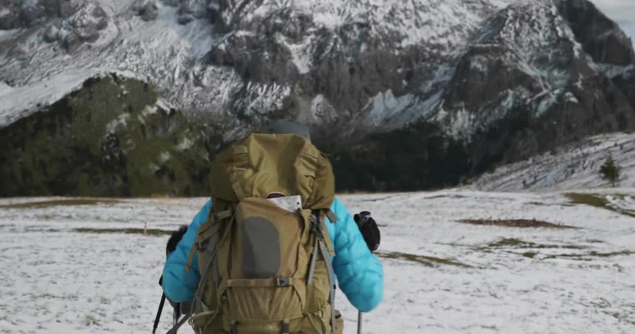 Two people hiking over snowy terrain