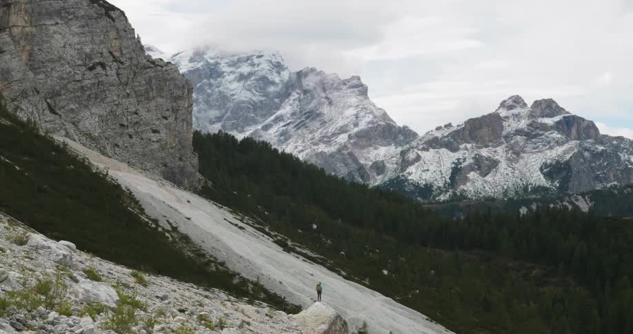 Person standing on a mountainside on a cloudy day