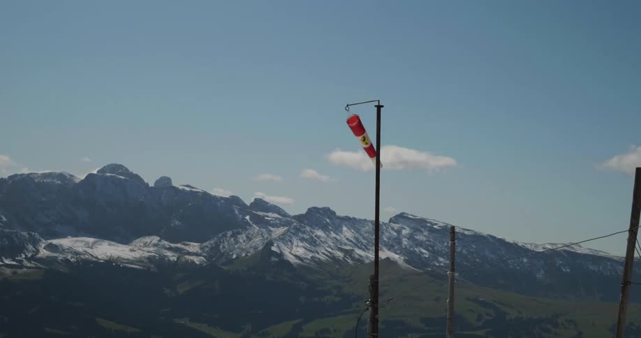A windsock blows in the wind atop a pole