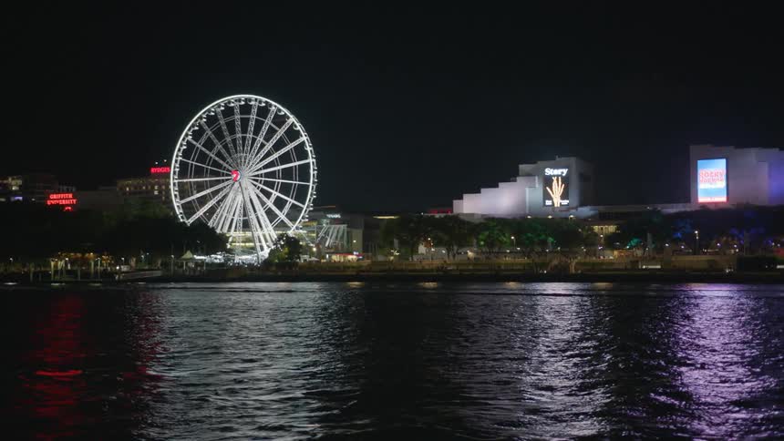 A ferris wheel near a lake at night