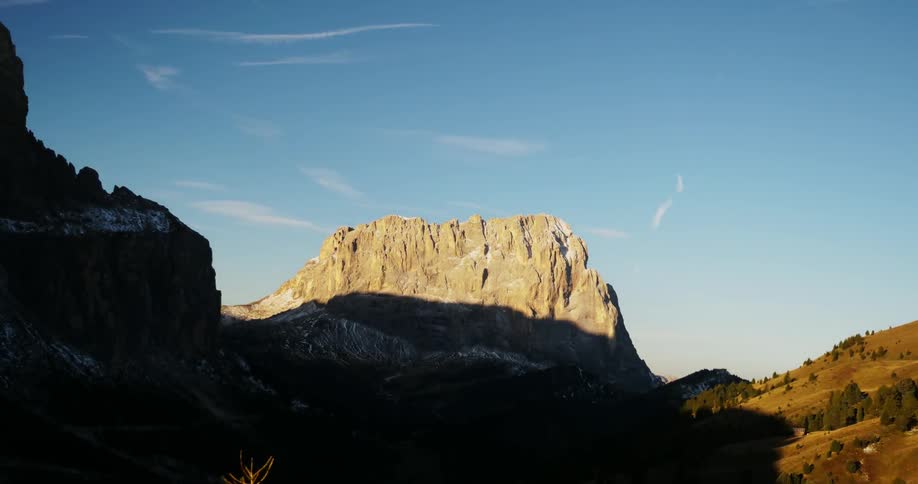 Shadows moving down tall rocky mountains