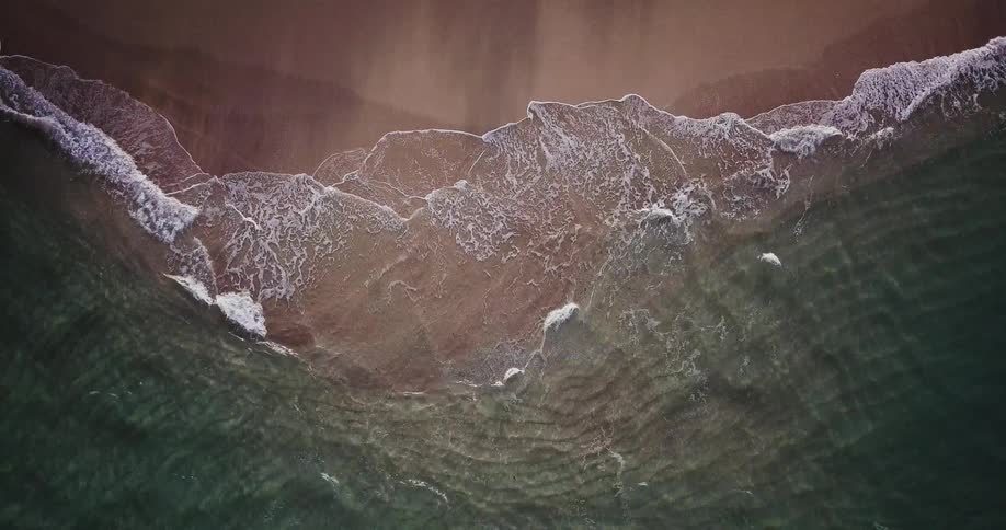 An overhead view of water coming into the beach