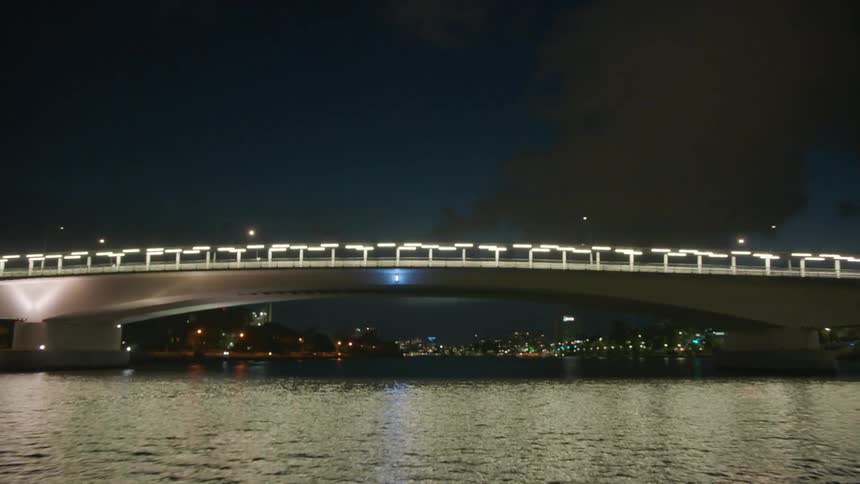 Lights under bridges light up the river at night