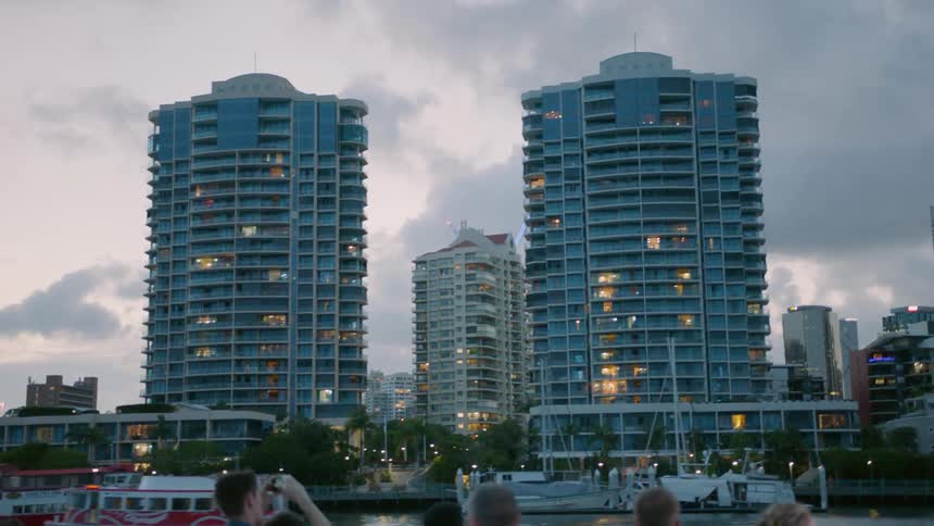 People take pictures of buildings from a boat