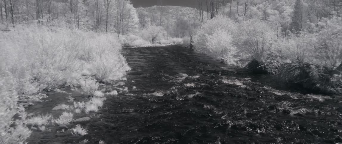 Close up view of a river flowing through snow covered areas