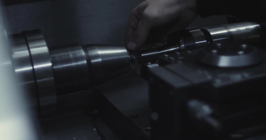 Hand unscrewing a bolt on a machine