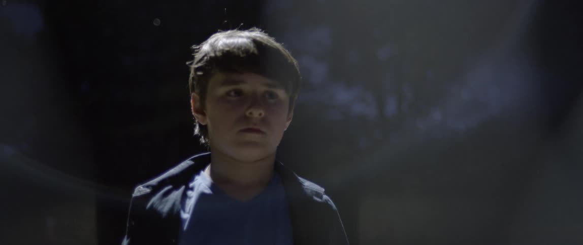 Child walks slowly outside at night