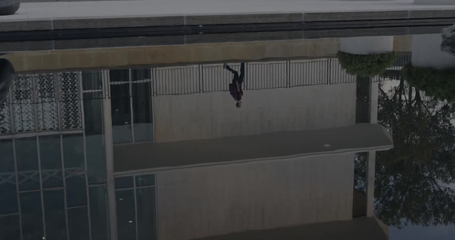 Reflection in a pool of water showing a person and building