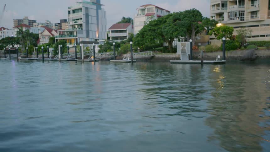 Traveling view down a river and houses on the shore