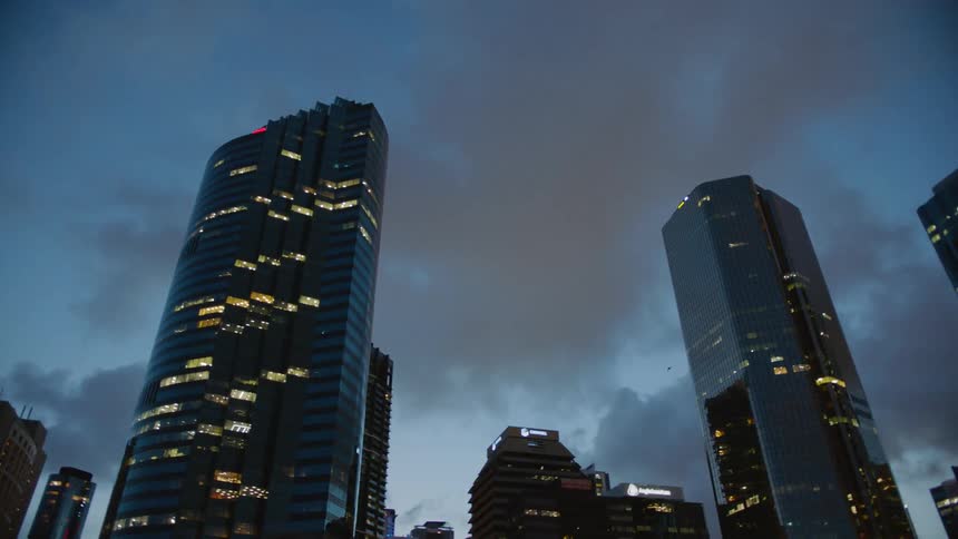 Lights shine in the skyscraper windows of a city skyline