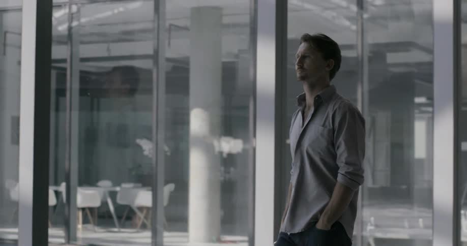 A man walks through a modern glass office building