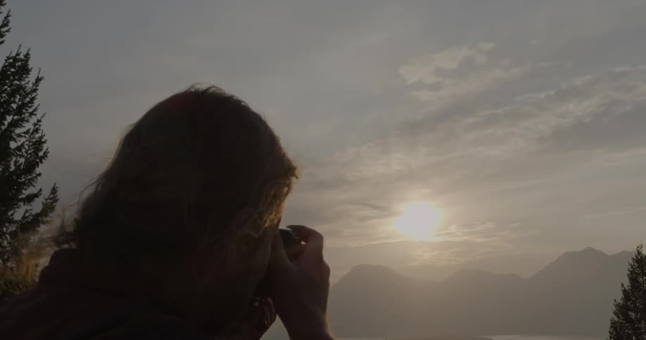 Person takes pictures of mountains on a sunny day