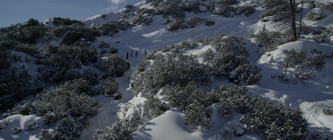 People are gathered on a snow covered mountain slope