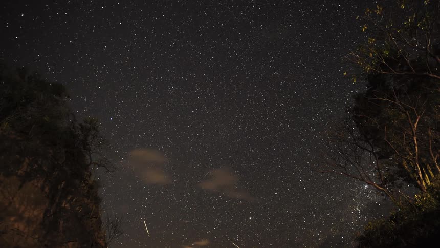 Clouds pass in a starry night sky