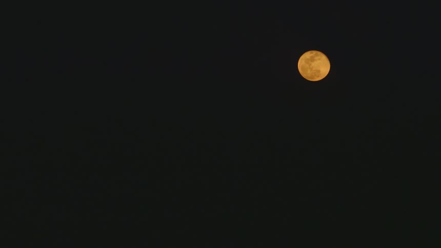 View of orange colored moon at night