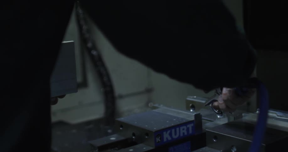 A person uses an air hose to clean equipment