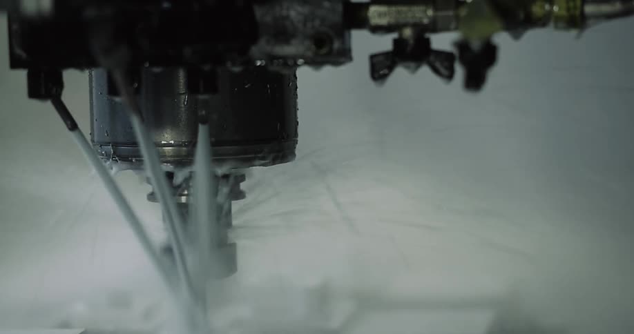A liquid sprays onto a drill as it operates