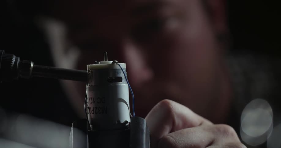 A person is soldering a wire to a component