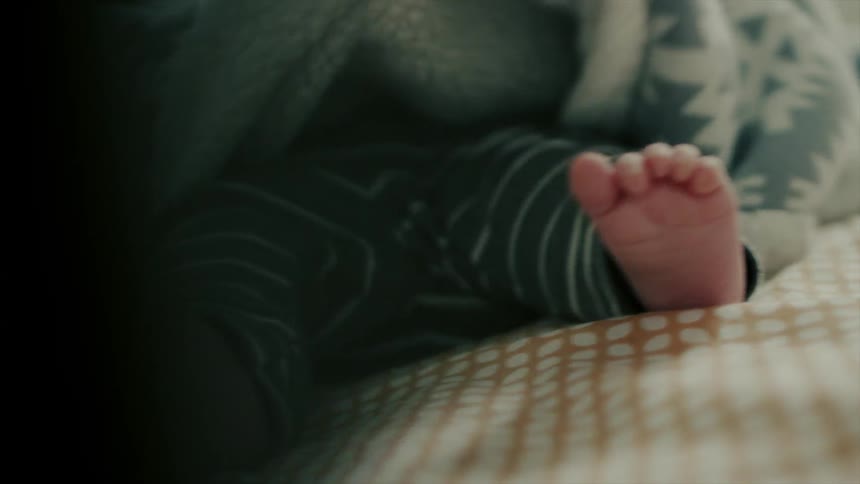 A person covers up a baby's feet