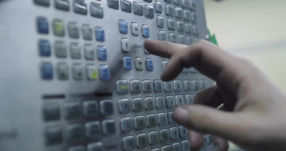 A person is pressing buttons on a panel in a building