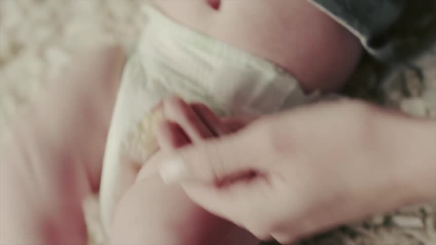 A woman puts a bandage onto a baby that doesn't have a cut