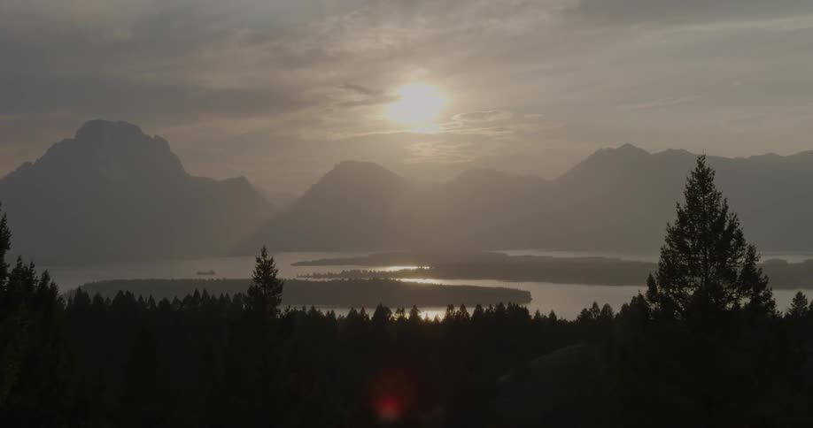 Sun rising over mountains and a lake