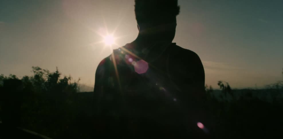 A man stands outside as the sun shines down on him