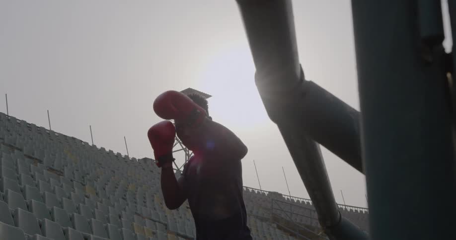 A man wearing boxing gloves punches the air