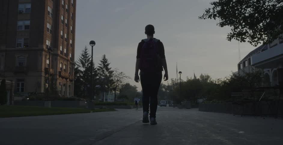 A woman is walking in a city concourse at dusk