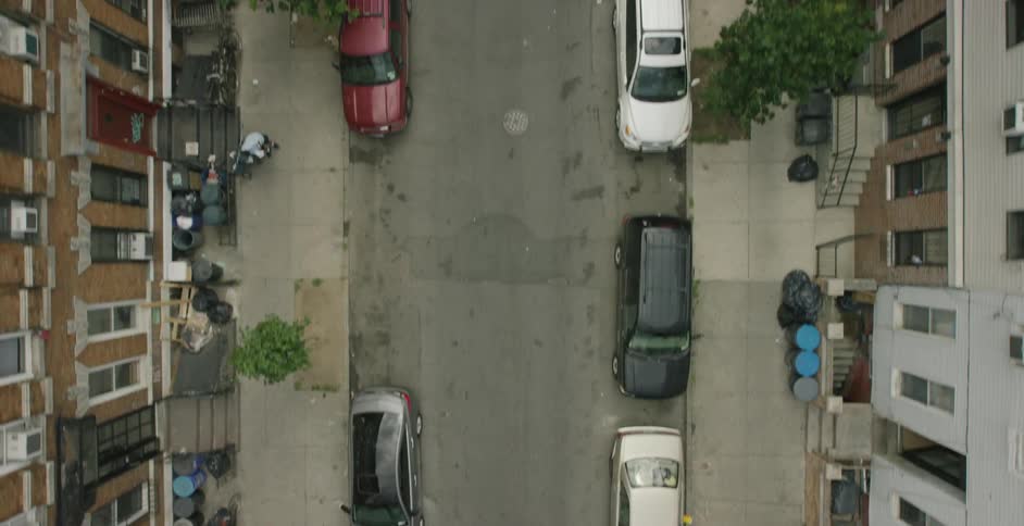 Cars line a city street as seen from above