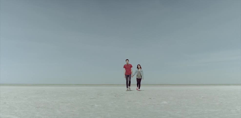 Man and woman walking on flat sandy land