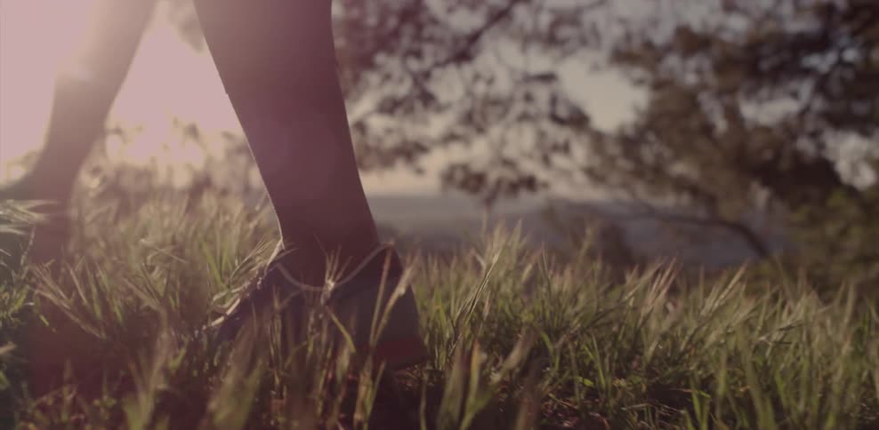 A hiker walks along the grass atop a hill