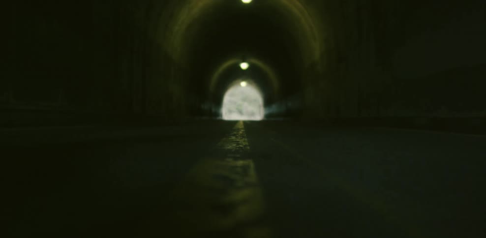 A woman is jogging through a tunnel during the day