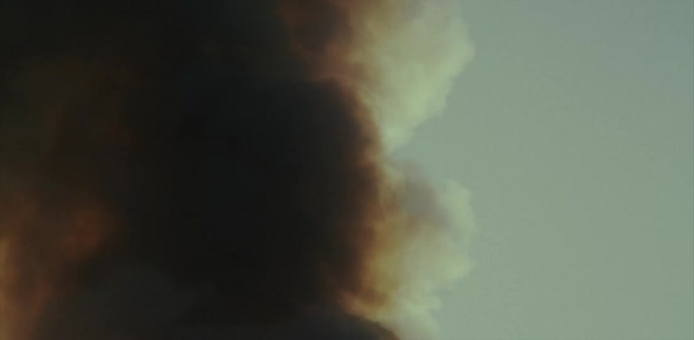 Smoke from a fires billows and curls in the sky during the day