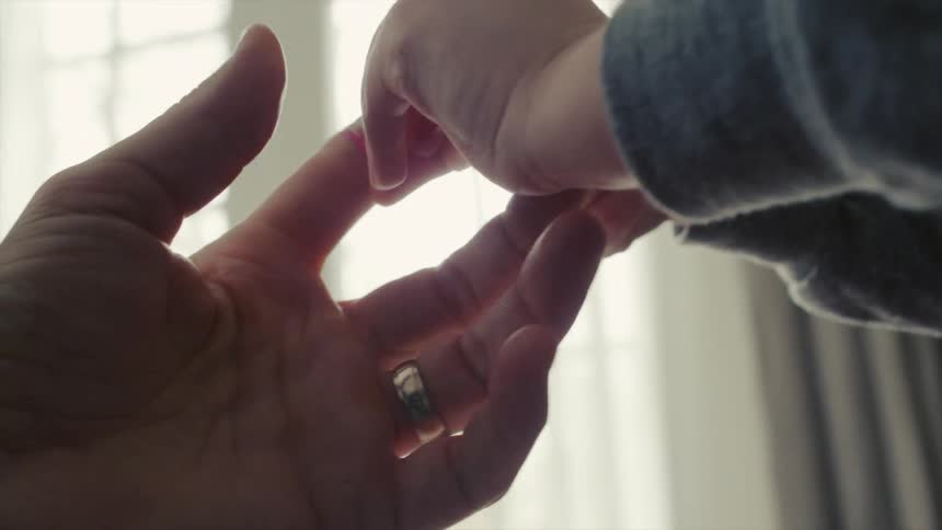 A child puts a band-aid on a man's finger