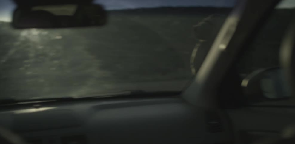 Car passes by a man wearing a backpack