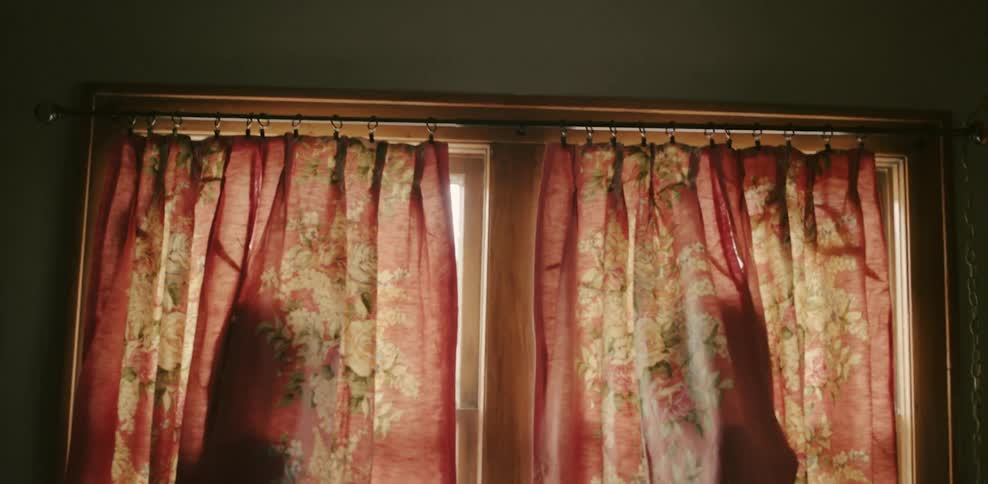 Two people hide in the curtains