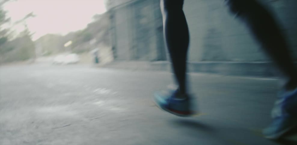 A person runs down the road through a tunnel