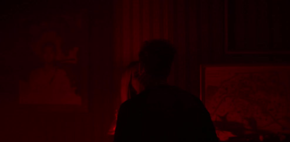 A man and woman kiss in a dark room